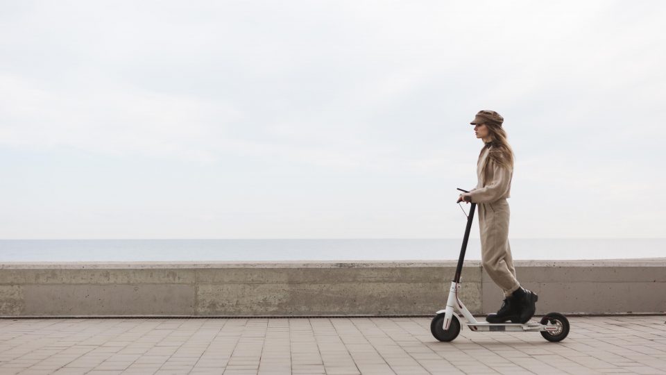 Moteris važinėjasi su elektriniu paspirtuku