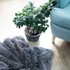 Pūkuotas pilkas pledas Springos interjere