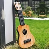 Mini ukulele žaislas vaikams, plastikinis gitaros žaislas, 4 stygos, muzikos instrumentas, realistiškas modelis, 25 x 9 x 2.7 cm, šviesiai ruda