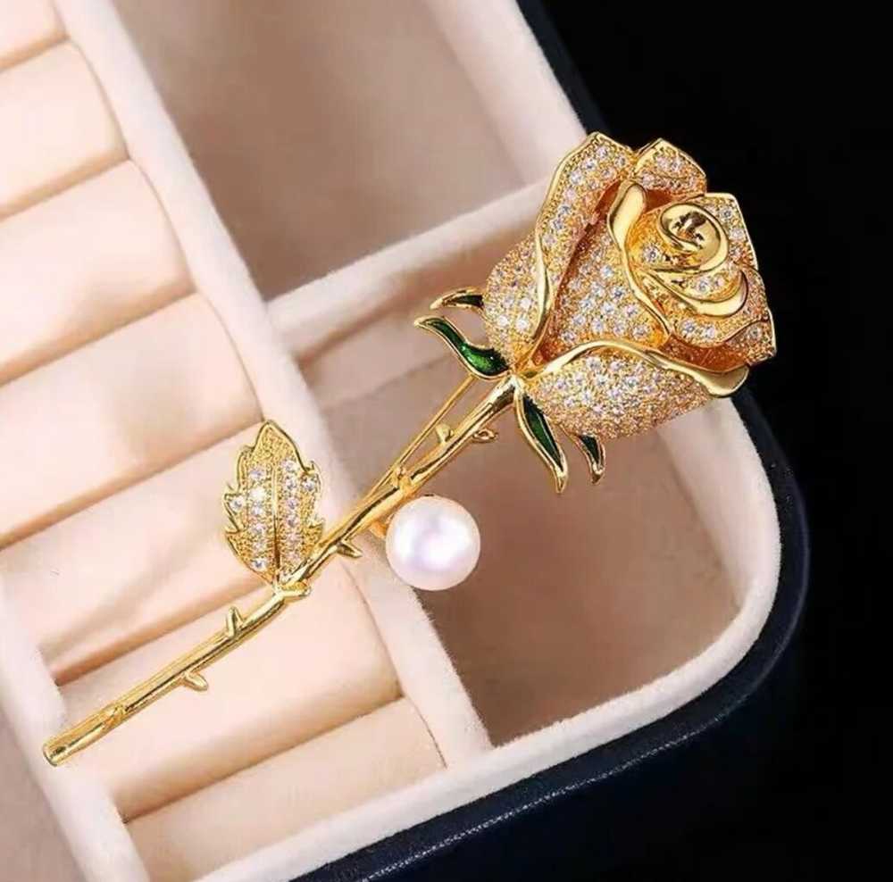 Elegantiška sagė su rože, dekoruota cirkoniais ir perlu E49