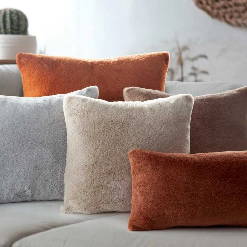Pūkuotos dekoratyvinės pagalvėlės įvairių spalvų kompozicijoje