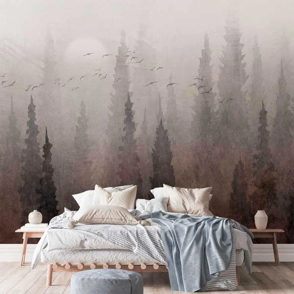 Artgeist Fototapetas - Bird's flight over treetops - landscape of a dark forest in fog