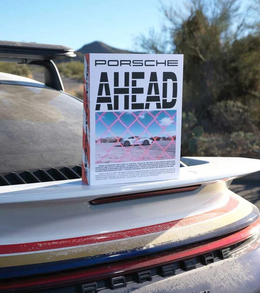 Knyga "PORSCHE AHEAD" prie kavos staliuko