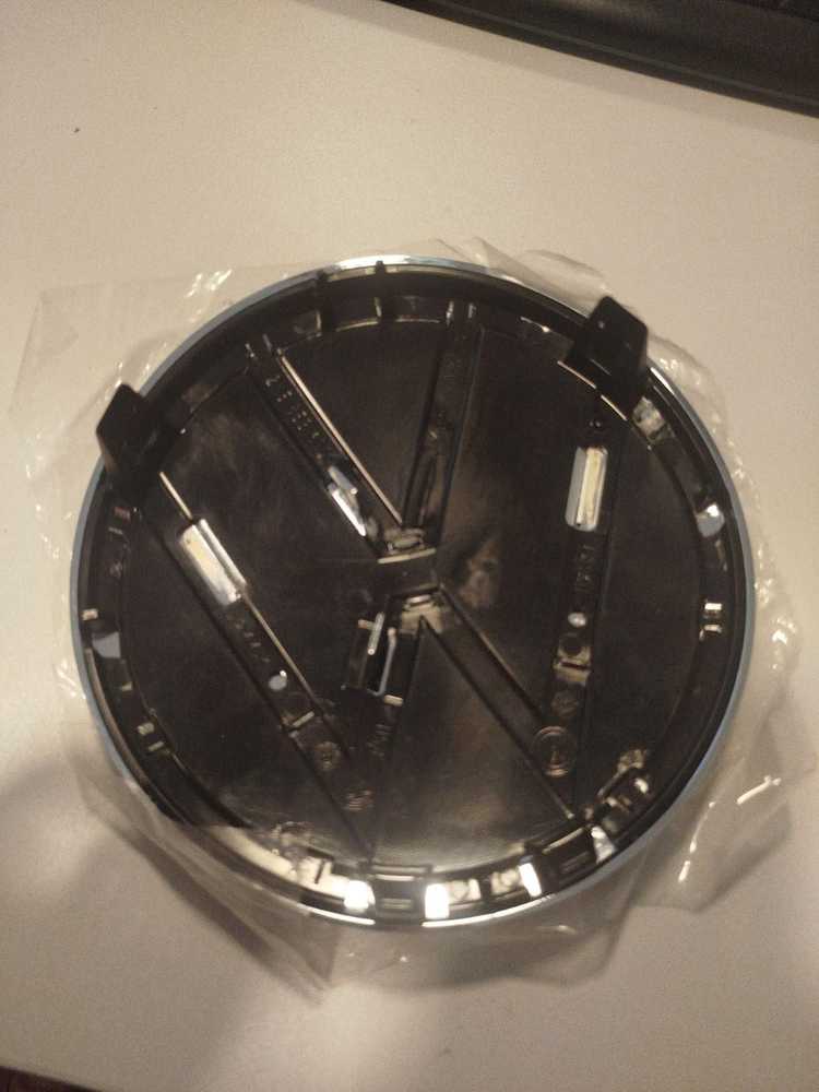 VAG VW TIGUAN priekinio bamperio radiatoriaus grotelės ženkliukas originalus 2K5853600