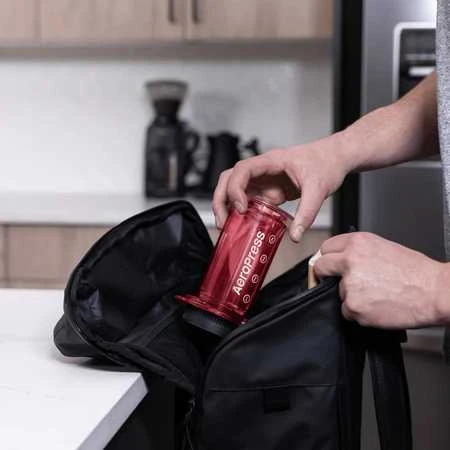 Raudonas AeroPress kavinukas kuprinėje