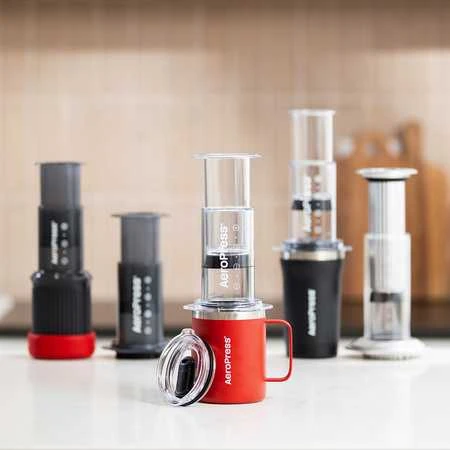 Raudonas „AeroPress“ kavos presas su puodeliu