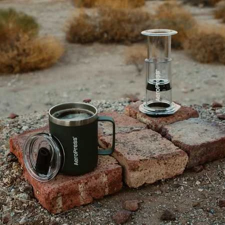 AeroPress kavos puodelis ir presas ant plytų