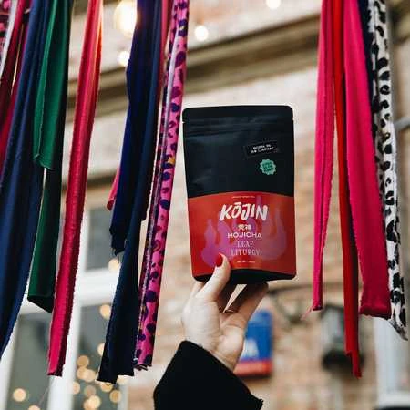 Kojin Hojicha arbatos pakuotė laikoma rankoje