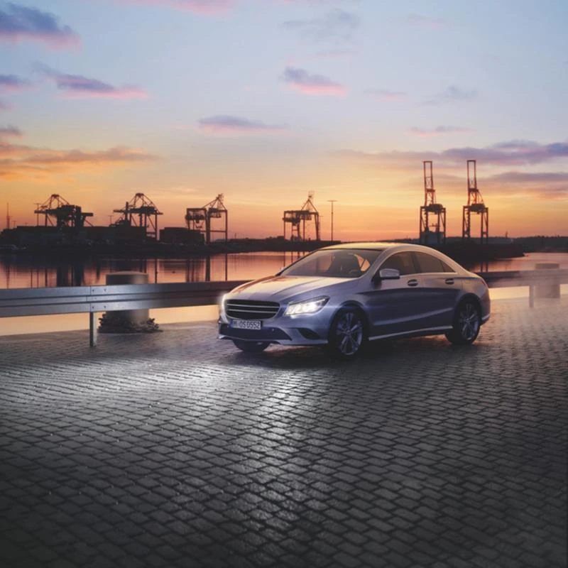 Automobilis su įjungtais žibintais prie uosto terminalo
