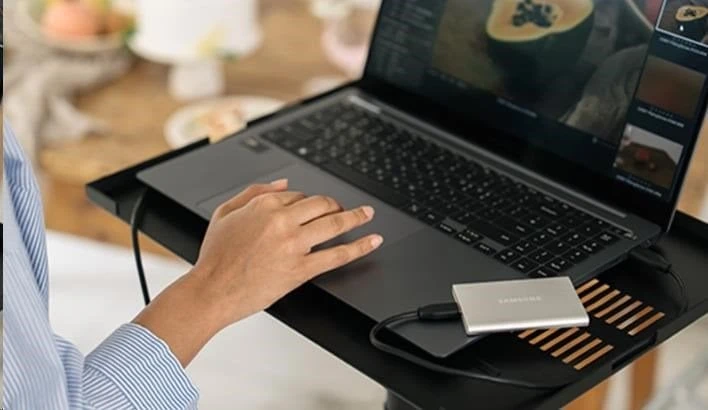 Kietasis diskas Nešiojamasis SSD diskas „Samsung T7 Resurrected 1TB“, kurio skaitymo sparta – 1050 MB/s, įrašymo sparta – 1000 MB/s.
