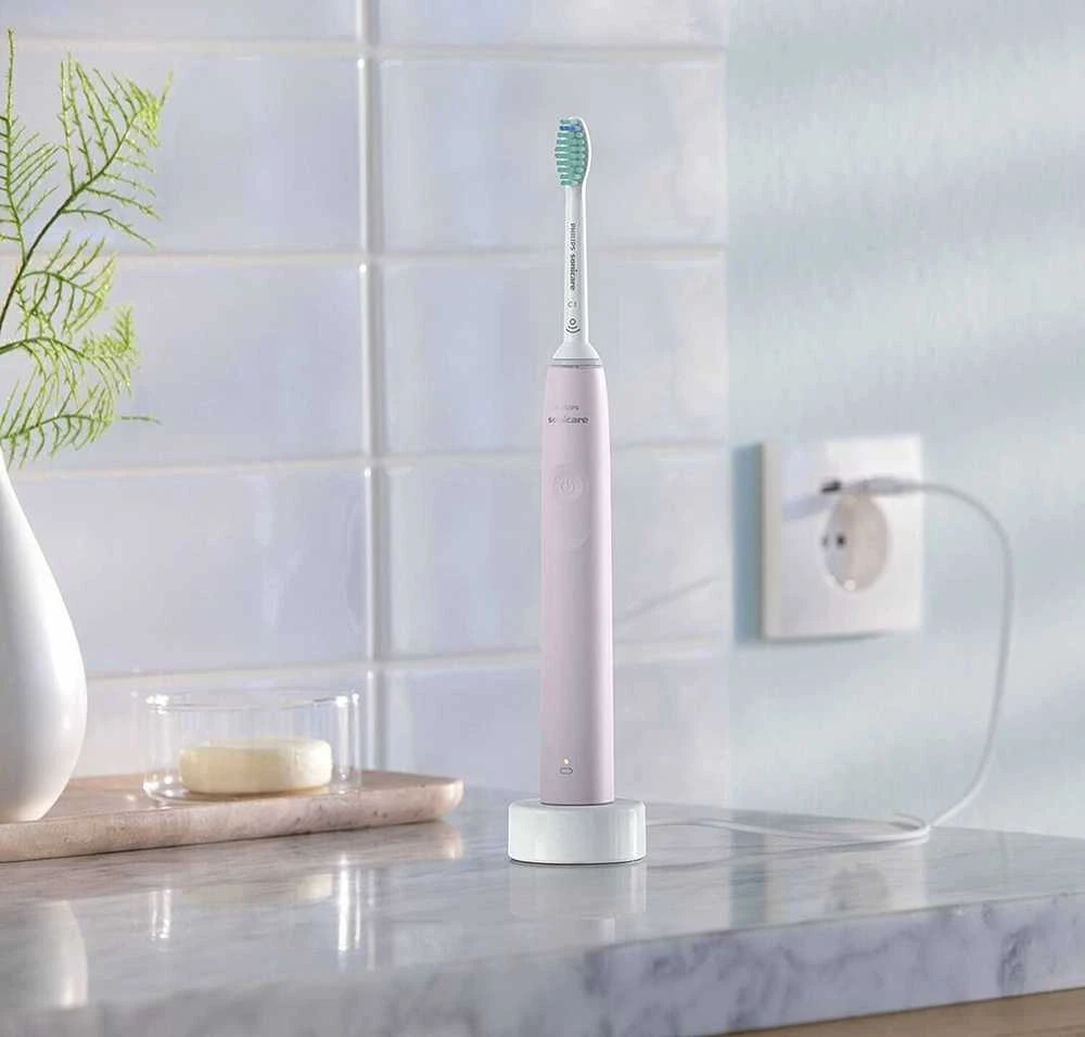 Philips Sonicare 3100 serijos rožinis dantų šepetėlis ant įkroviklio