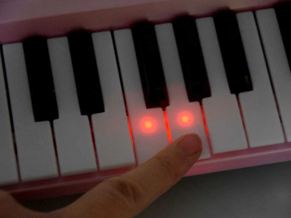 Vaikiškas pianinas su mikrofonu ir šviečiančiais klavišais, rožinis