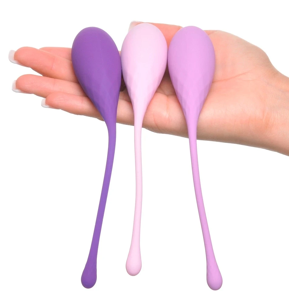 Trijų skirtingų atspalvių violetiniai Kegel rutuliukai delne