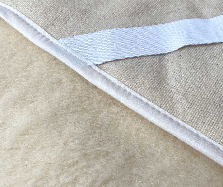 Merino vilnos čiužinio apsauga, natūrali spalva, 135x200 cm, vieno sluoksnio flisas, elastingi dirželiai, ekru apvadas, lovos užtiesalas