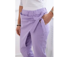 Moteriškos kelnės su asimetrišku priekiu ir raišteliu, šviesiai violetinės spalvos