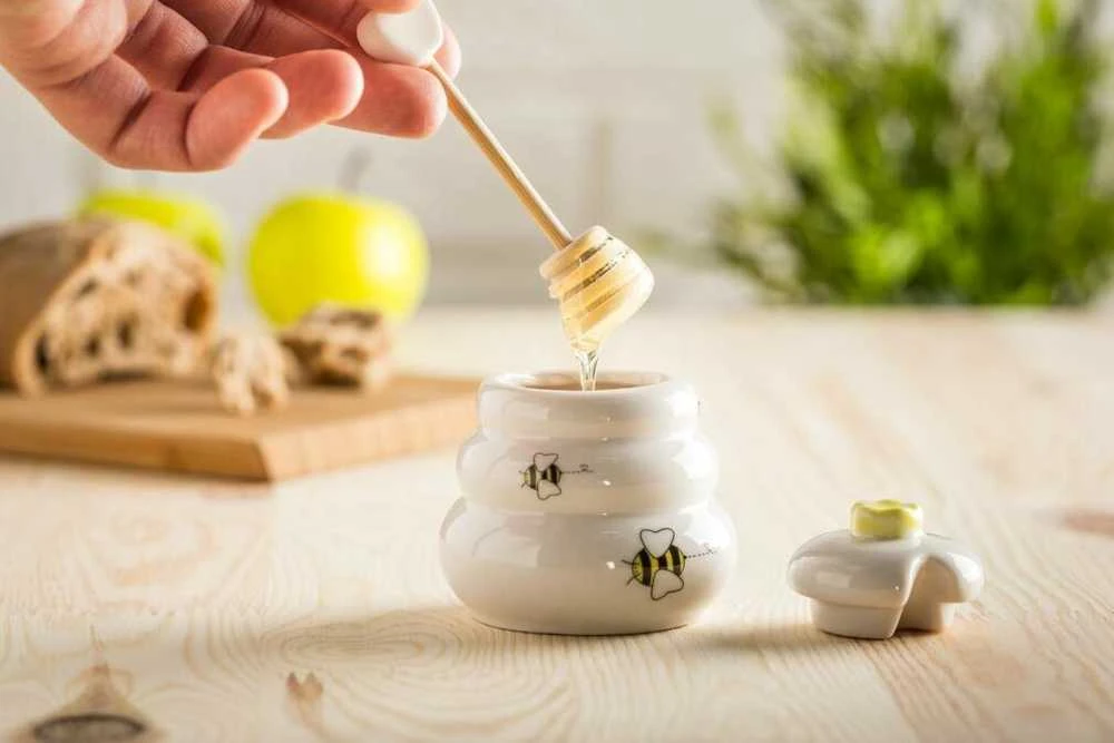 Porcelianinis medaus indelis su medine lėkštute