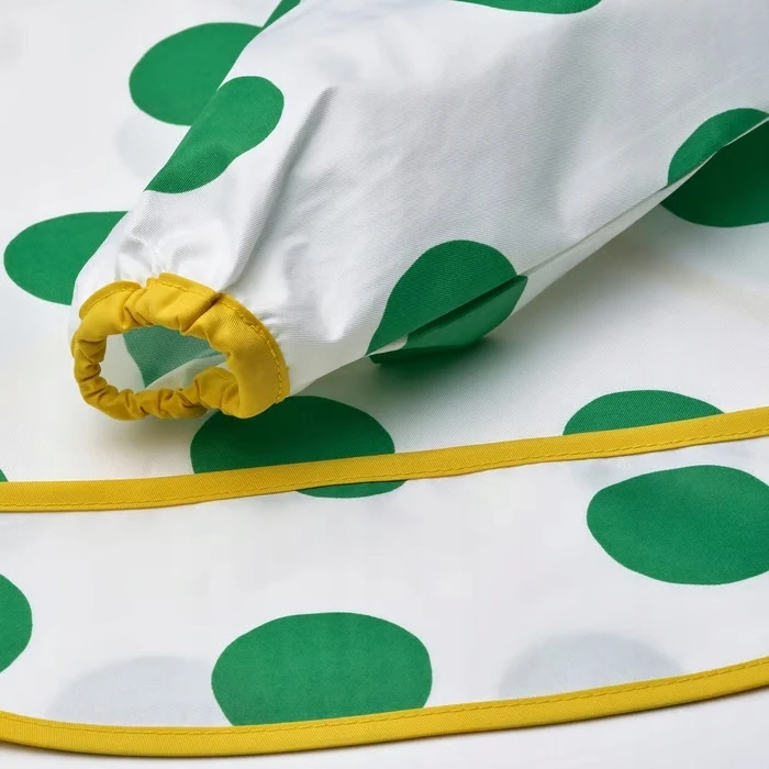 IKEA KLADDIG Prijuostės seilinukas su rankovėmis, baltais ir žaliais taškeliais