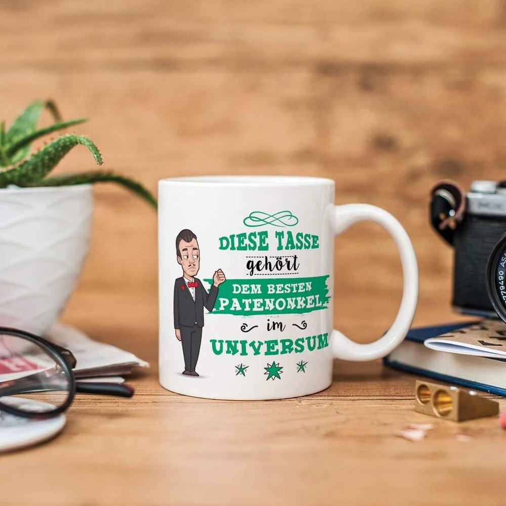 Mugffins puodelis krikštatėviui su vokišku tekstu "bester Patenonkel im Universe" (geriausias krikštatėvis visatoje). Gražus ir juokingas kavos puodelis kaip dovana krikštatėviui, keraminis, 350 ml