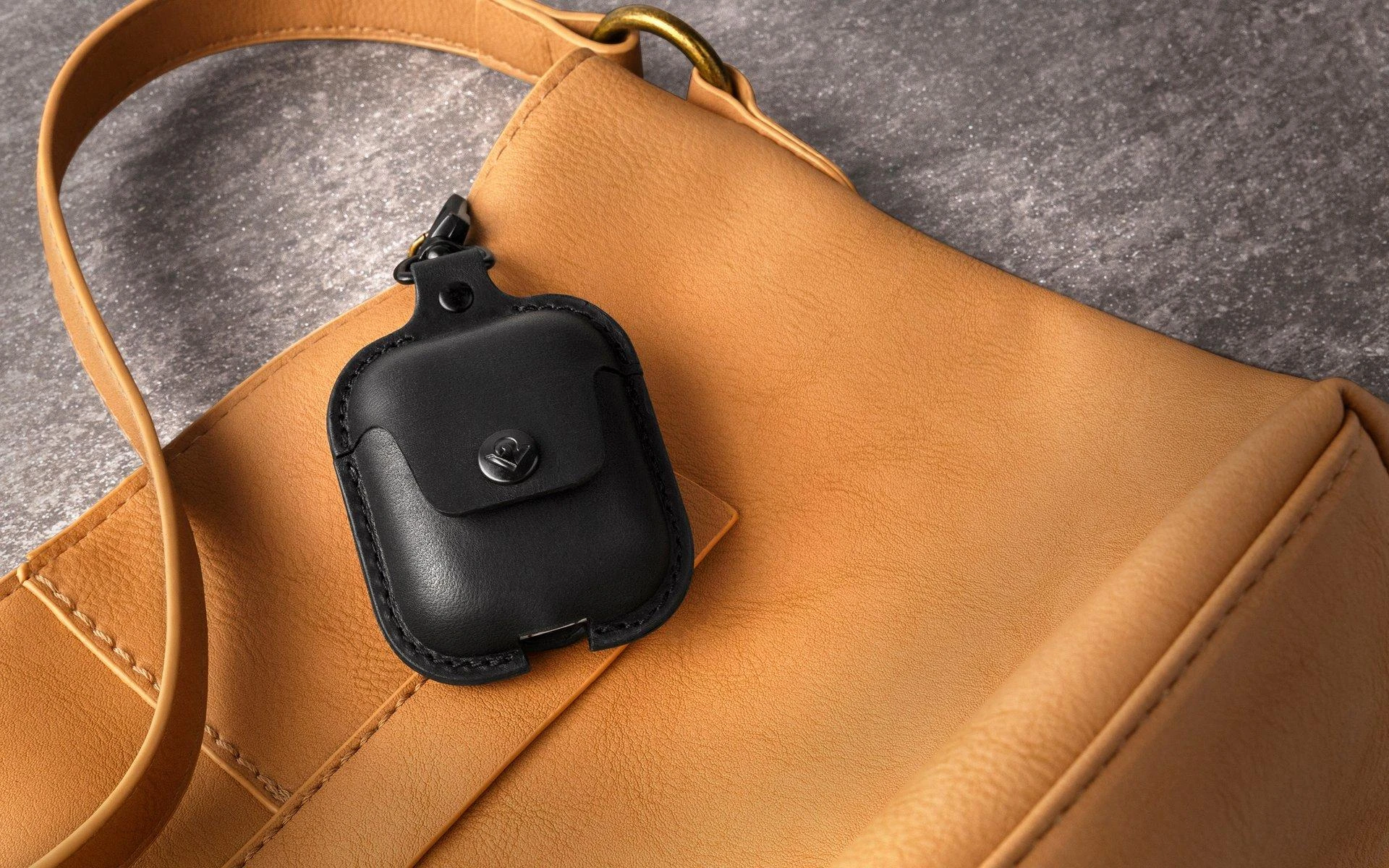 Juodas odinis AirSnap AirPods dėklas prie rankinės