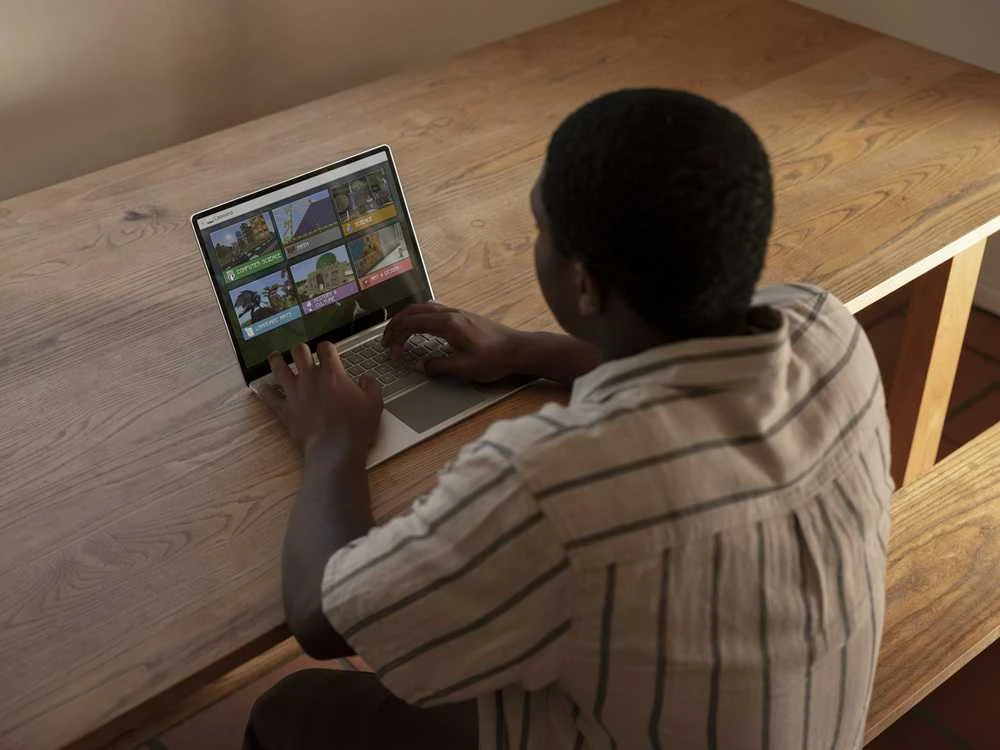 Microsoft Surface Laptop Go naudojant prie medinio stalo