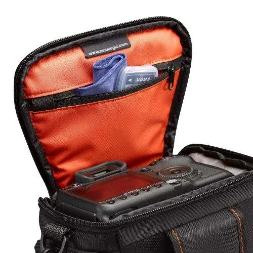 Case Logic Atvejo logika | DCB-306 SLR fotoaparato krepšys | Juodas | * Sukurta taip, kad tilptų veidrodinis fotoaparatas su standartiniu priartinimo objektyvu * Vidinėje užtrauktuku užsegamoje kišenėje saugomos atminties kortelės, filtras arba objektyvo audinys * Šoninėse kišenėse su užtrauktuku galima laikyti papildomą bateriją, kabelius, objektyvo dangtelį ar mažus priedus * Dangtis atsegamas, kad būtų galima plačiai atsidaryti lengva ir greita prieiga prie fotoaparato rankenos * Paminkštintas pagrindas apsaugo jūsų fotoaparatą ir objektyvą * Integruota diržo kilpa, paminkštinta rankena ir nuimamas peties dirželis siūlo daugybę nešiojimo galimybių