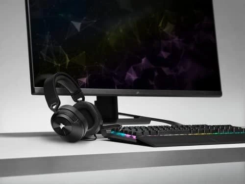 Corsair HS55 ausinės ant stalo šalia kompiuterio