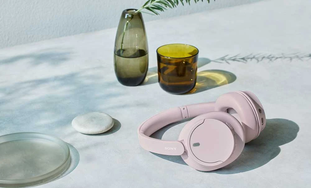 Sony WH-CH720N rožinės ausinės ant stalo