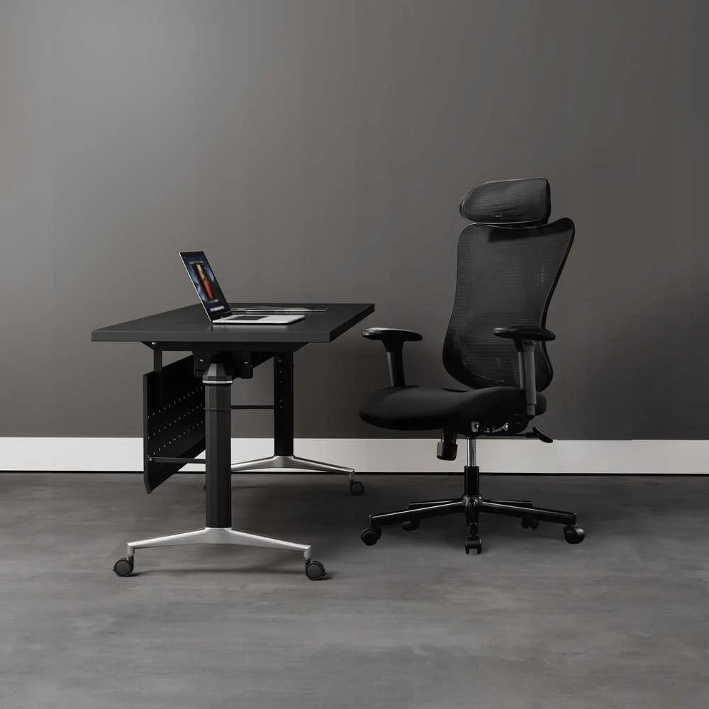 Juoda ergonomiška biuro kėdė darbo vietoje