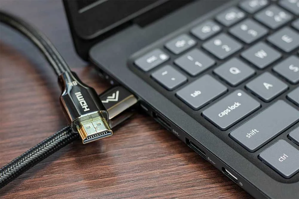 Juodas pintas HDMI laidas prie kompiuterio