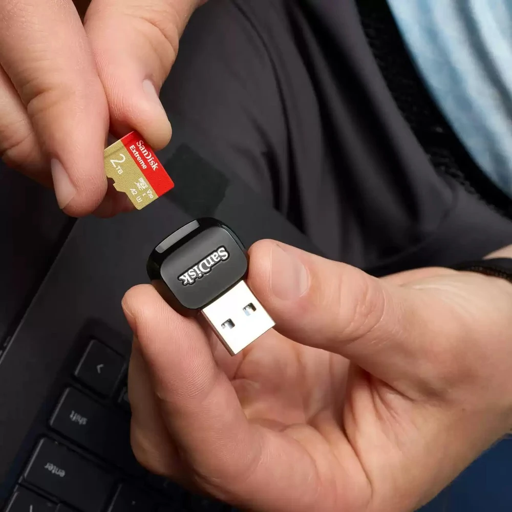 SanDisk Micro SD kortelė su USB adapteriu rankose