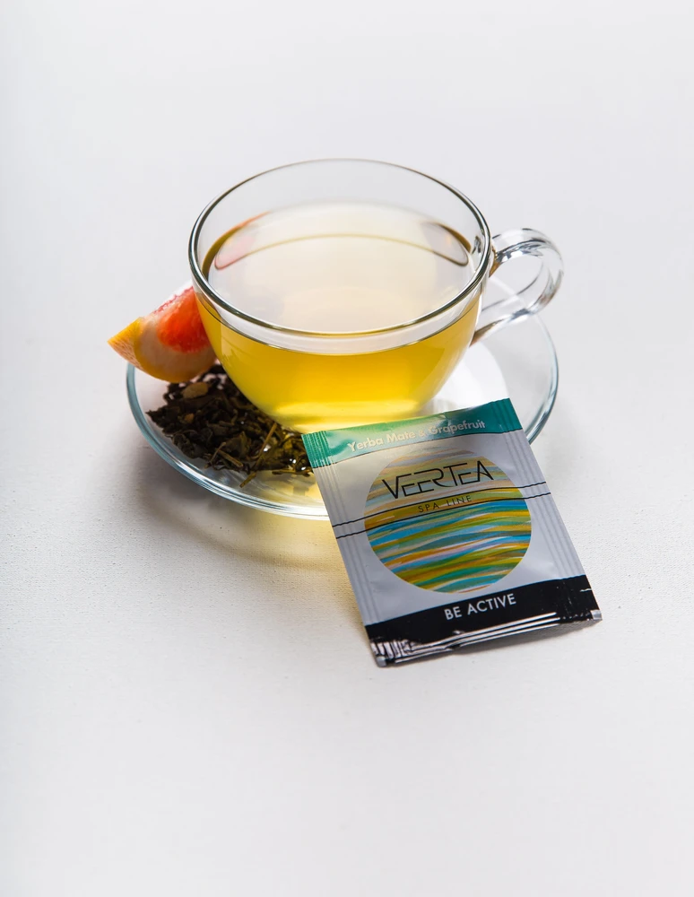 Veertea arbatos puodelis su greipfrutu ir arbatos paketėliu