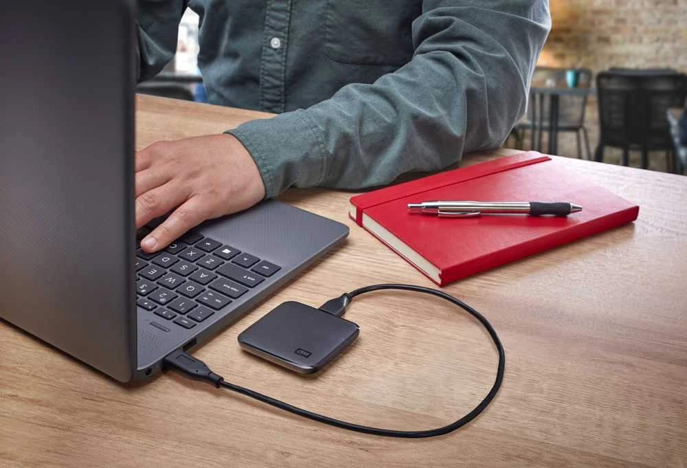Kietasis diskas „Sandisk Western Digital Elements SE SSD 1TB“ – nešiojamas SSD diskas, kurio skaitymo greitis siekia 400 MB/s, atsparumas kritimui iš 2 metrų aukščio
