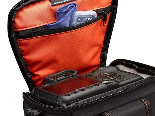 Case Logic Atvejo logika | DCB-306 SLR fotoaparato krepšys | Juodas | * Sukurta taip, kad tilptų veidrodinis fotoaparatas su standartiniu priartinimo objektyvu * Vidinėje užtrauktuku užsegamoje kišenėje saugomos atminties kortelės, filtras arba objektyvo audinys * Šoninėse kišenėse su užtrauktuku galima laikyti papildomą bateriją, kabelius, objektyvo dangtelį ar mažus priedus * Dangtis atsegamas, kad būtų galima plačiai atsidaryti lengva ir greita prieiga prie fotoaparato rankenos * Paminkštintas pagrindas apsaugo jūsų fotoaparatą ir objektyvą * Integruota diržo kilpa, paminkštinta rankena ir nuimamas peties dirželis siūlo daugybę nešiojimo galimybių