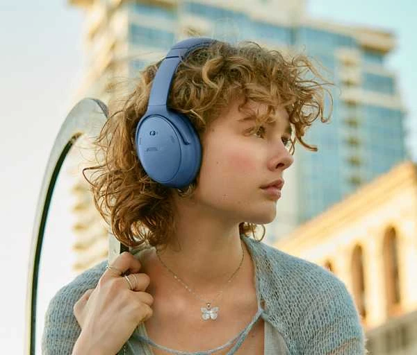 Bose QuietComfort mėlynos ausinės ant ausų