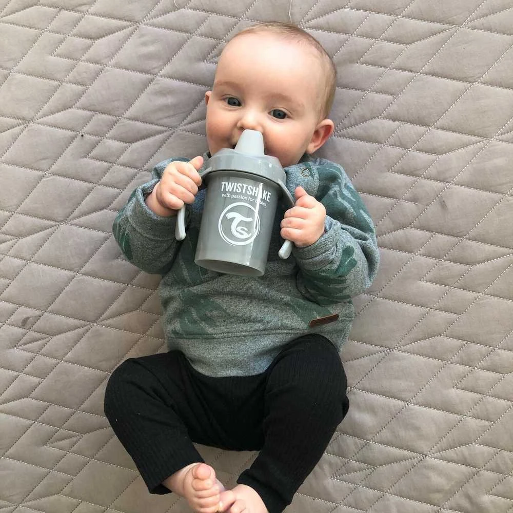 Twistshake pilka gertuvė kūdikio rankose
