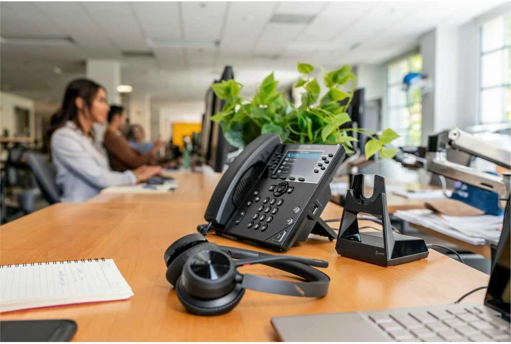 Poly Voyager 4320 ausinės su įkrovimo stotele ant stalo